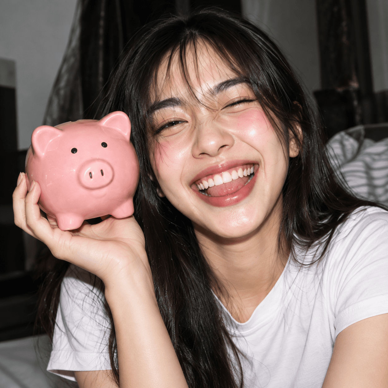หญิงสาวยิ้มถือกระปุกออมสินหมูสีชมพู